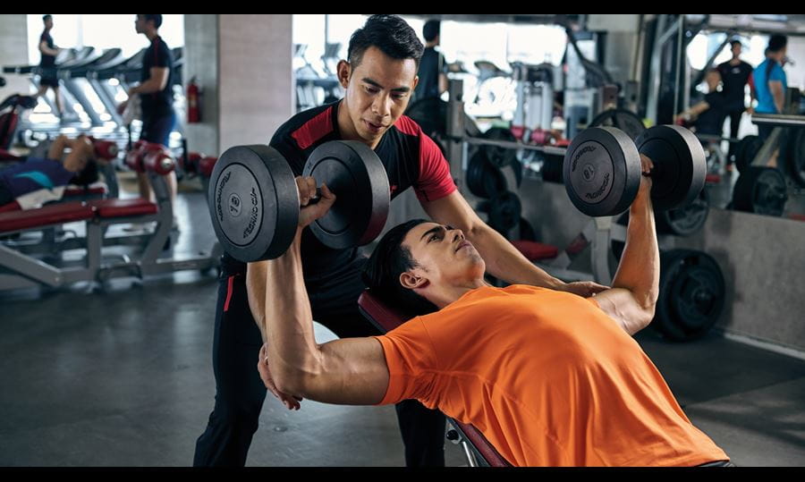 Man lifting weights in sweat wicking attire 