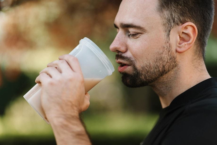Man drinking a protein-shake during his fitness workout.